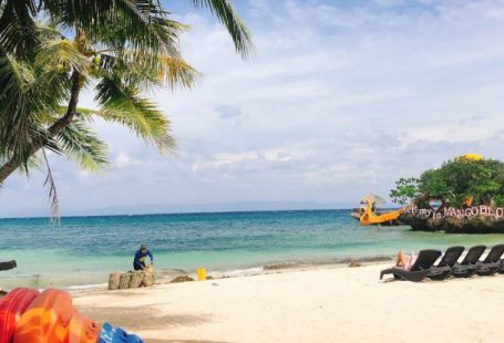 Sustainable Volunteering - Man cleaning tropical sandy beach