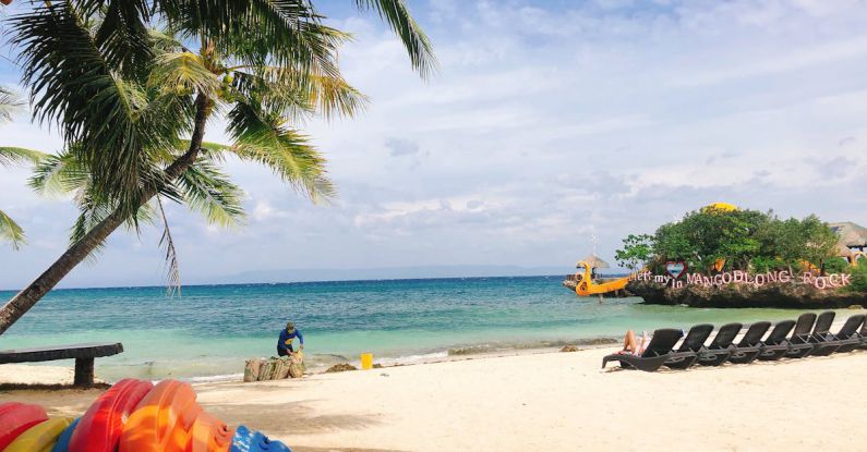 Sustainable Volunteering - Man cleaning tropical sandy beach