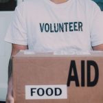 Volunteer Organizations - Volunteer Holding Box of Food Aid