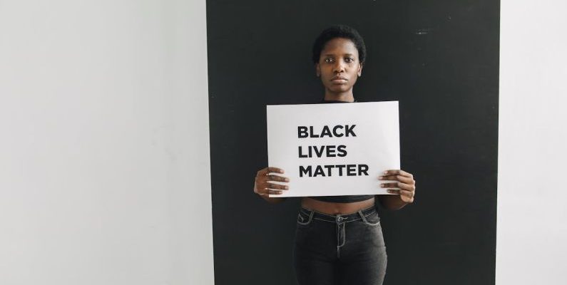 Inclusive Spaces - A Woman Holding a Card with Words Black Lives Matter