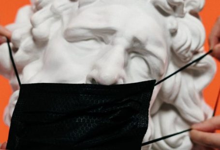 Public Health Campaigns - People Holding Mask Over A Sculpture